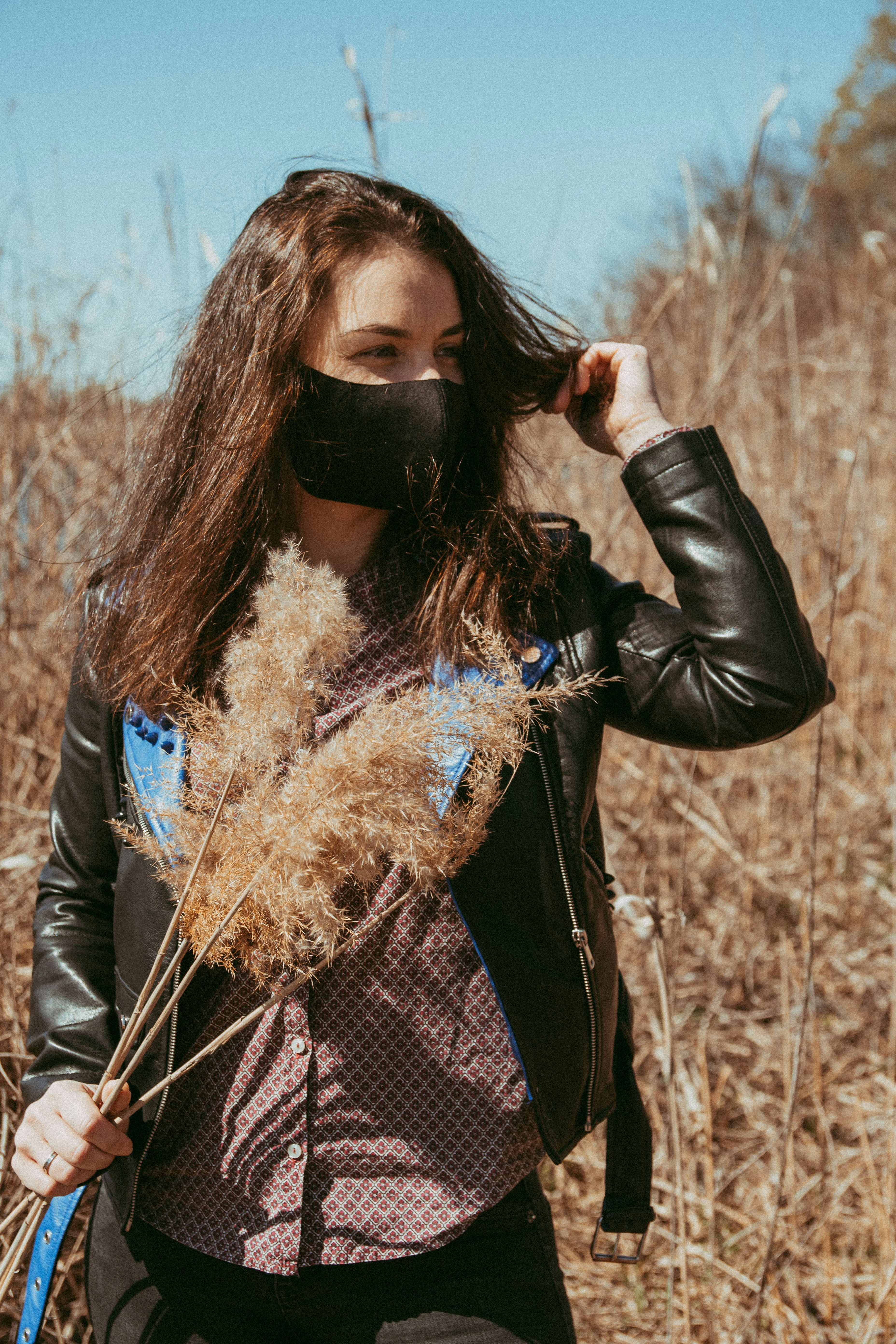 woman in black leather jacket with brown and white scarf